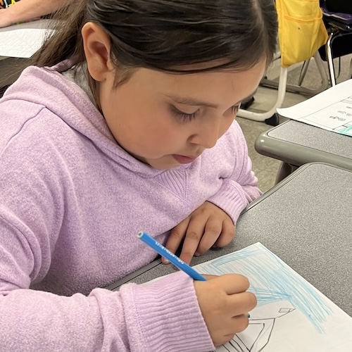  A young student with head down focused on coloring